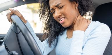 Black woman with whiplash in a car