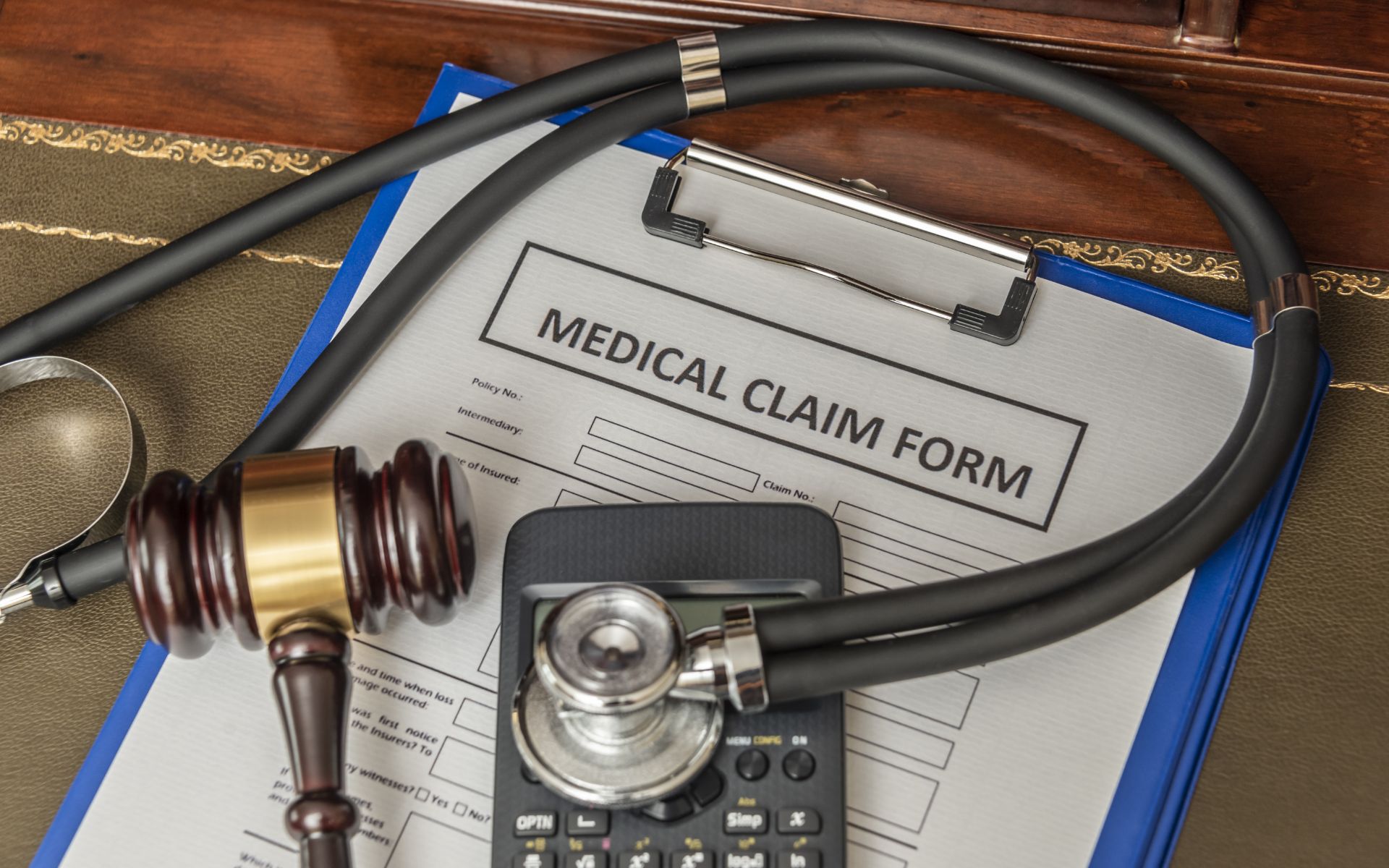 Medical claim form with stethoscope and gavel.